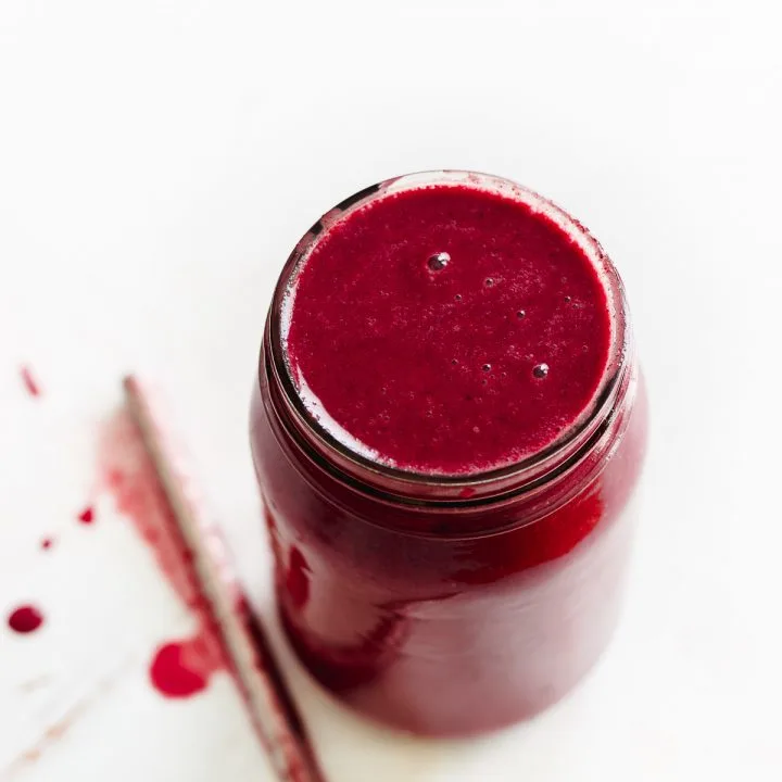 frozen berry smoothie in a jar with straw