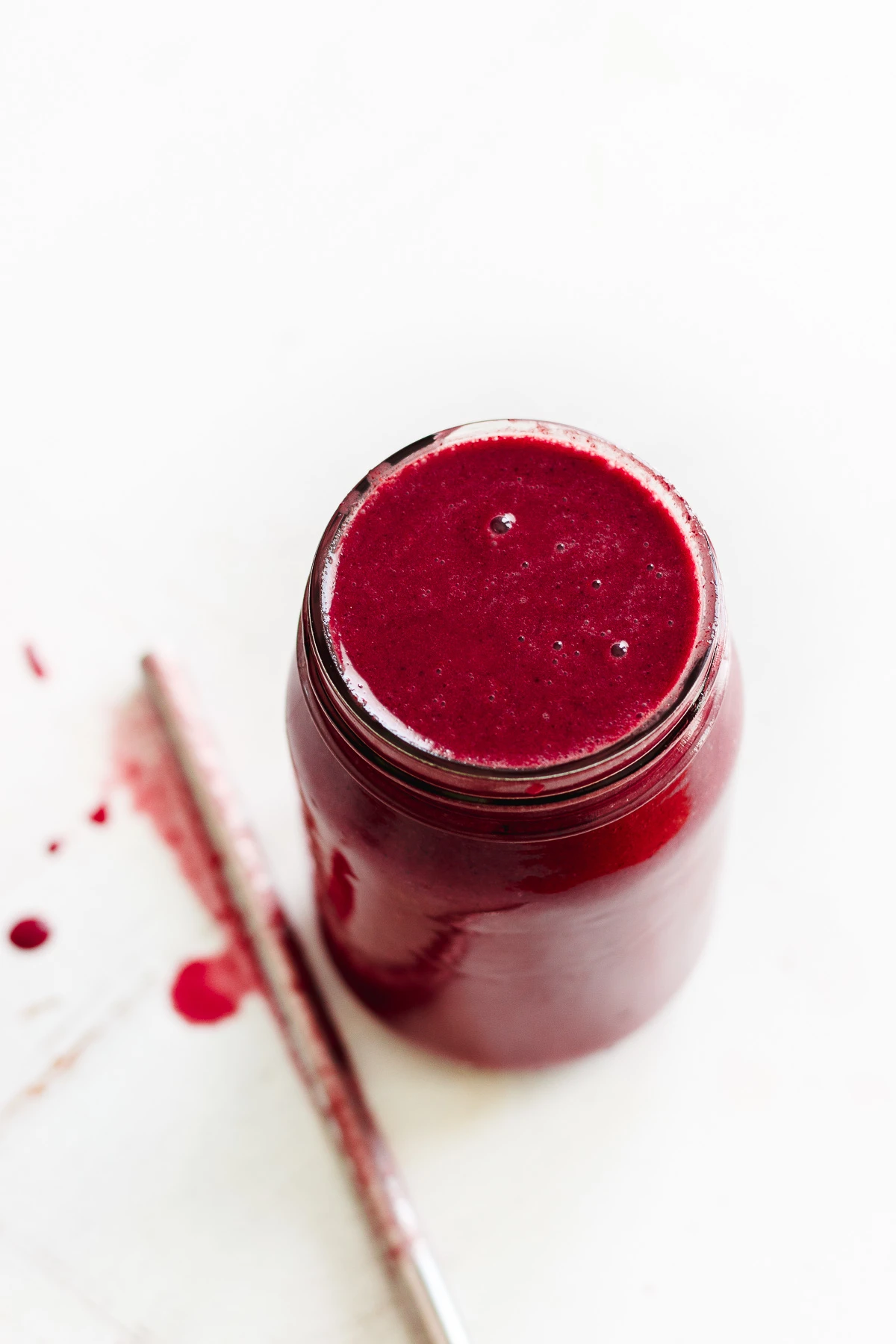 frozen berry smoothie in a jar with straw