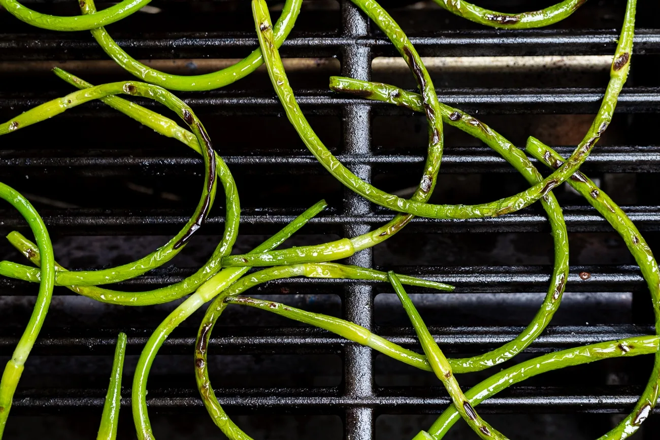 charred garlic scapes on the grill