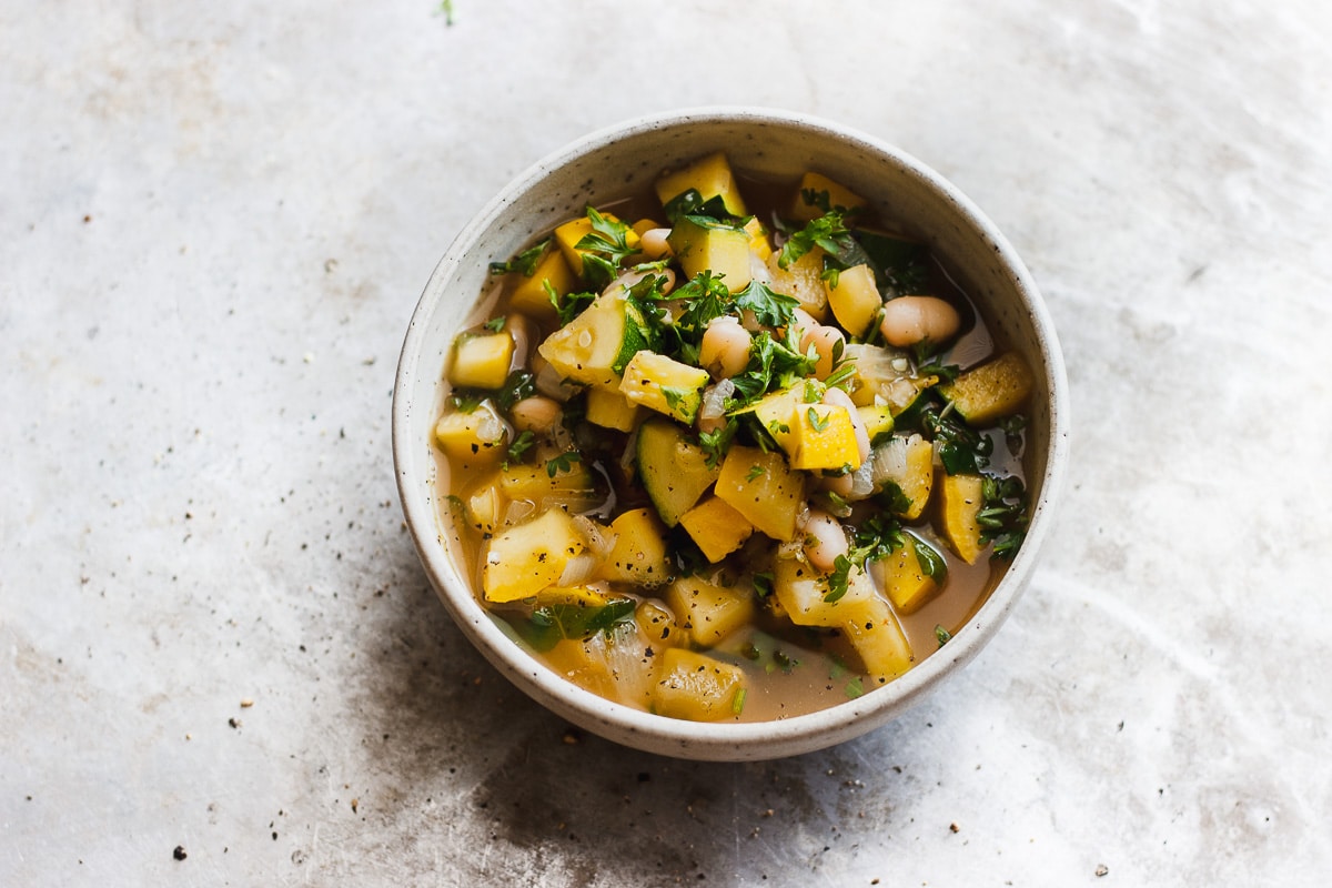 zucchini soup with white beans in a bowl