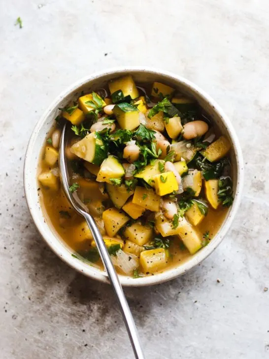 summer squash soup with white beans in a bowl