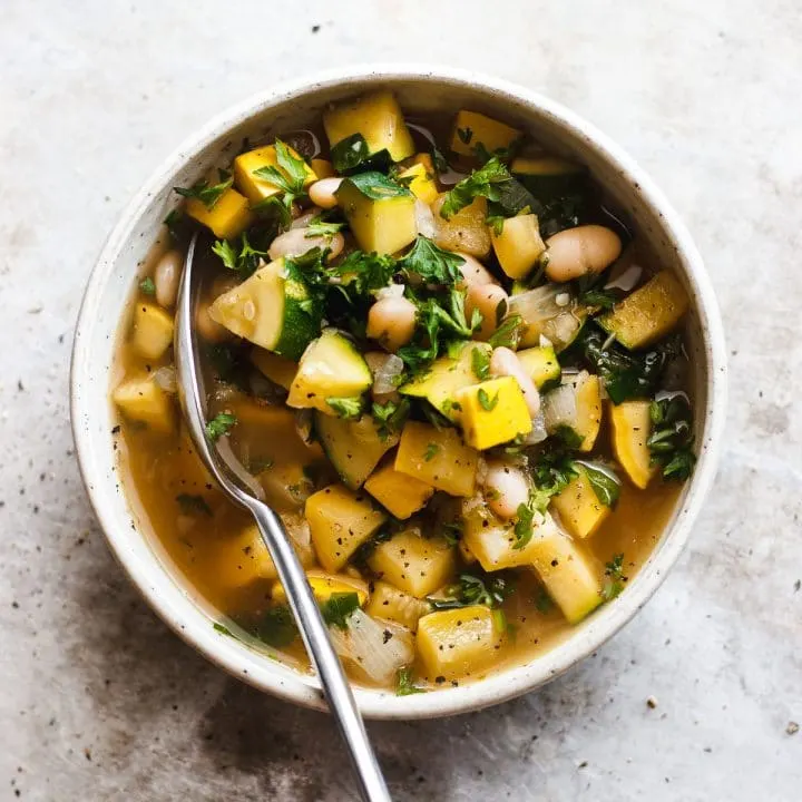 summer squash soup with white beans in a bowl