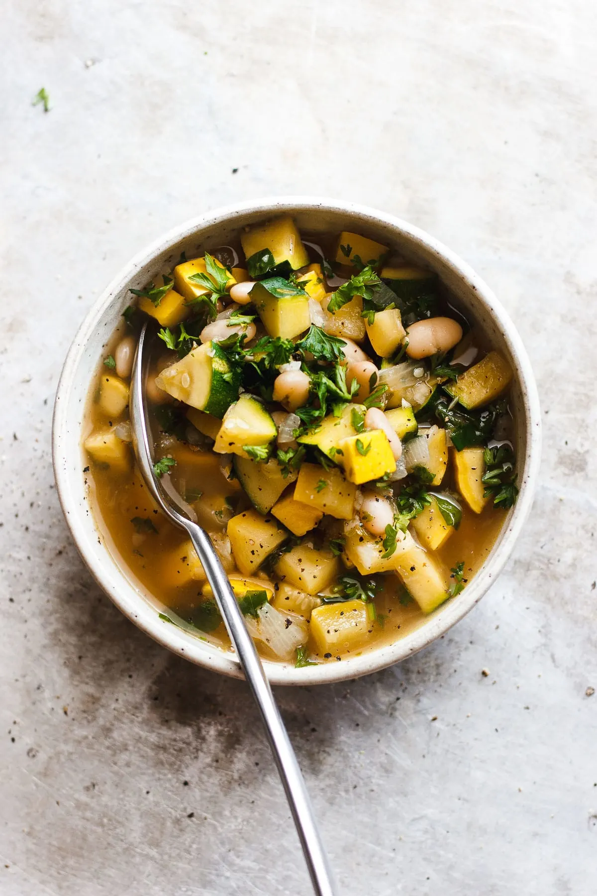 summer squash soup with white beans in a bowl