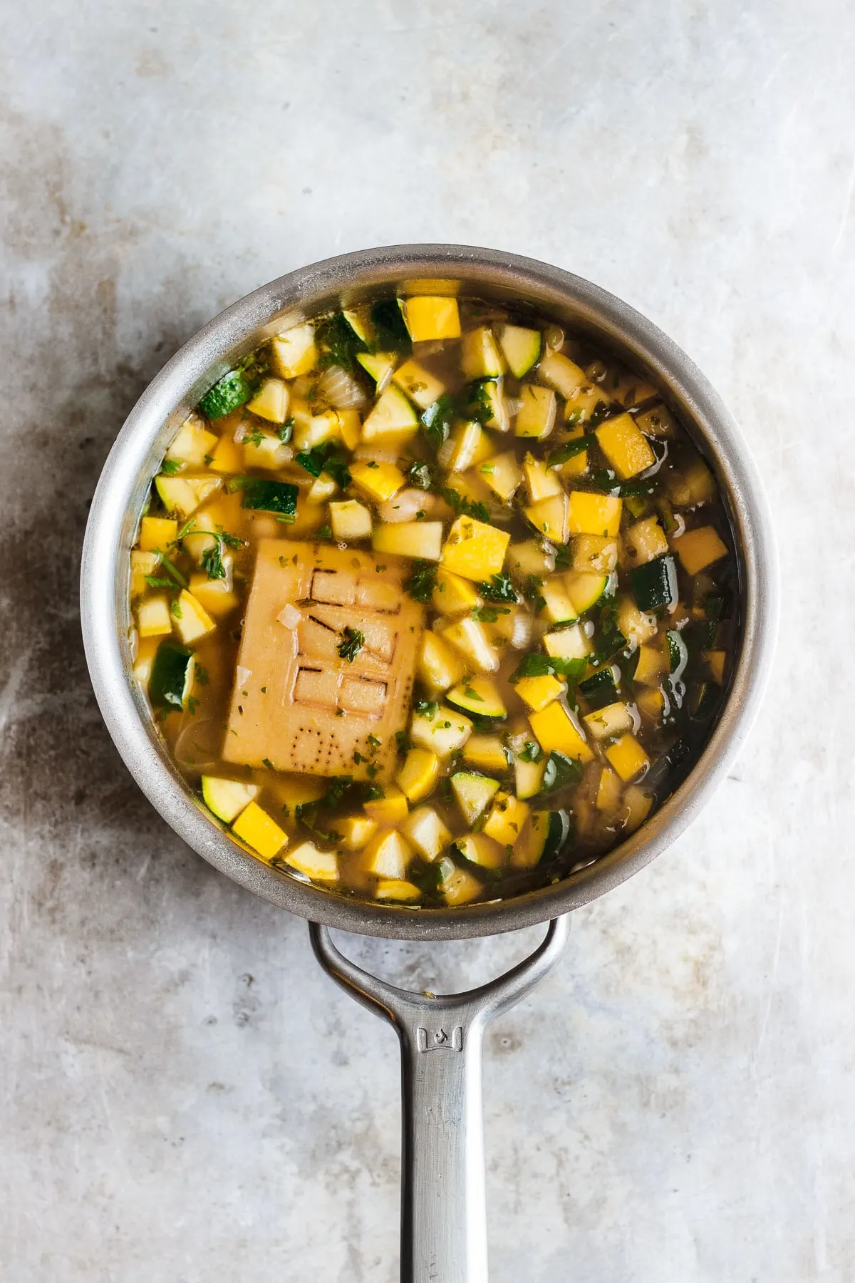 zucchini soup in a pot with parmesan rind