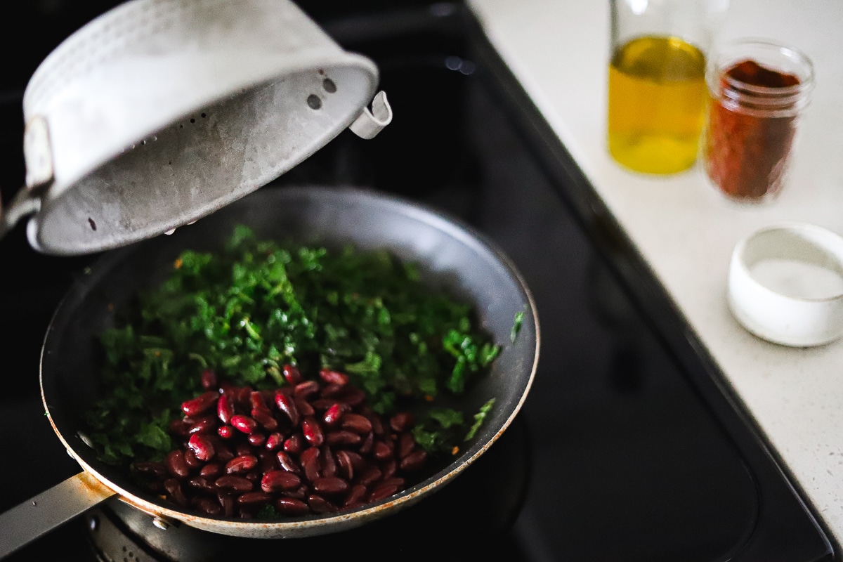 kale and kidney beans simmering in a pan