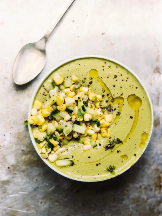Chilled Cream of Basil Soup with Corn + Cucumber Salad | Cream of basil soup made naturally vegan with raw cashews and herbs. Topped with a fresh, crunchy summer salad of corn and cucumber. Creamy, chilled, summer soup.
