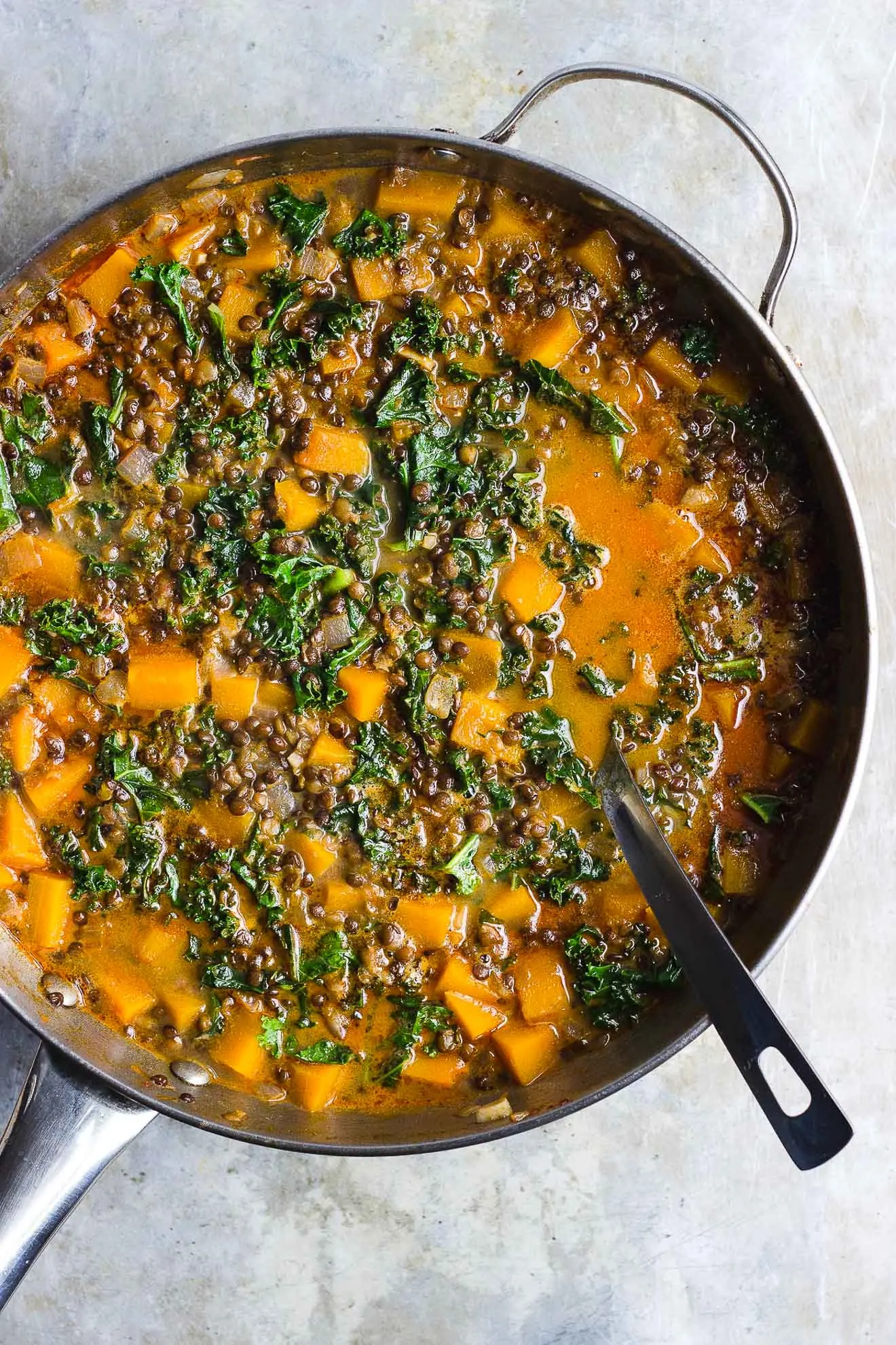 Red Curry Lentil Stew with Butternut Squash + Kale | Red curry lentil stew with butternut squash, kale and creamy coconut milk. It's naturally gluten-free and vegan. It's a hearty fall lentil stew. #butternutsquashrecipes #fallstew #lentilstew