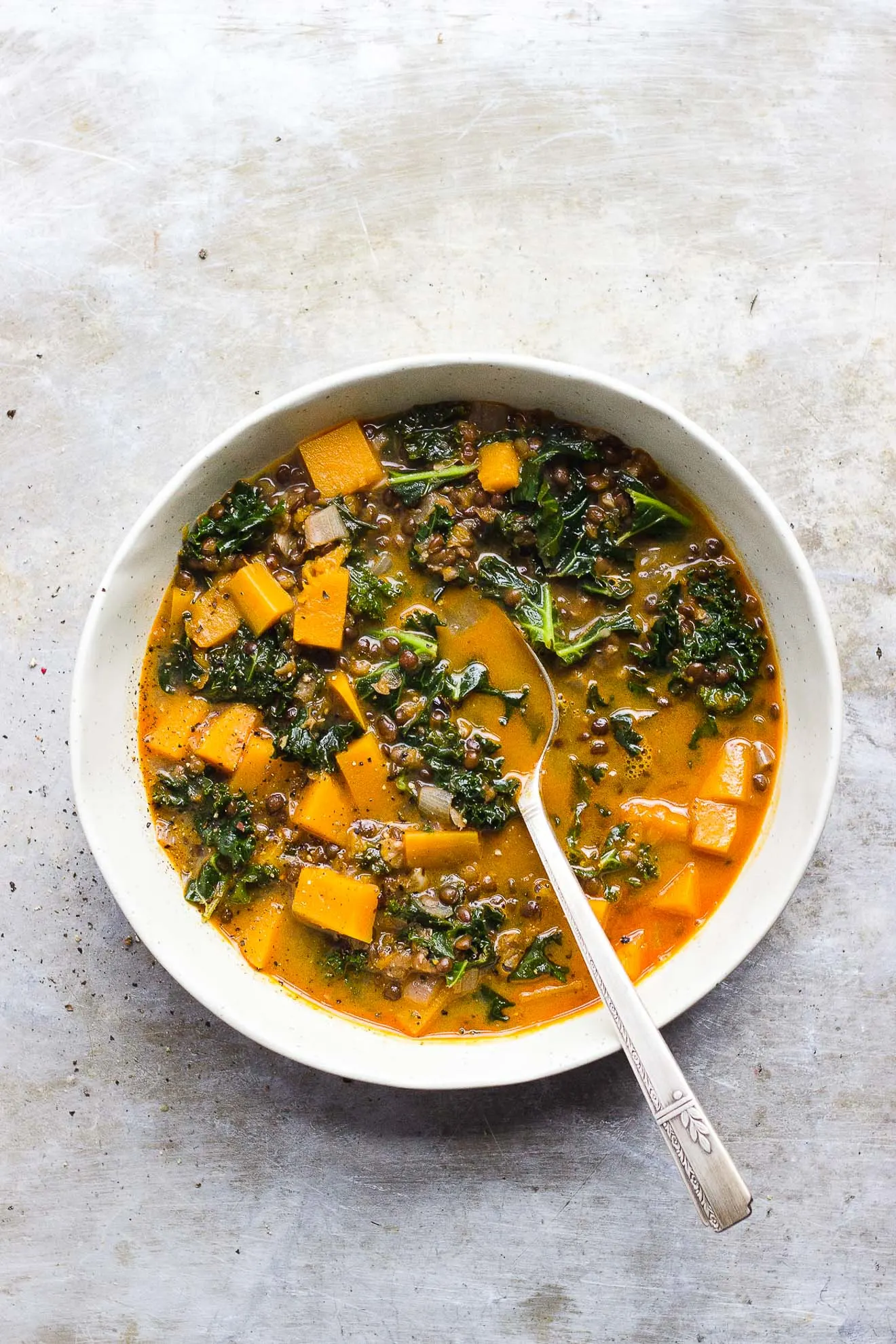 Red Curry Lentil Stew with Butternut Squash + Kale | Red curry lentil stew with butternut squash, kale and creamy coconut milk. It's naturally gluten-free and vegan. It's a hearty fall lentil stew. #butternutsquashrecipes #fallstew #lentilstew