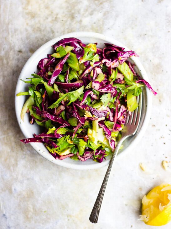 red cabbage celery salad in a bowl with lemon