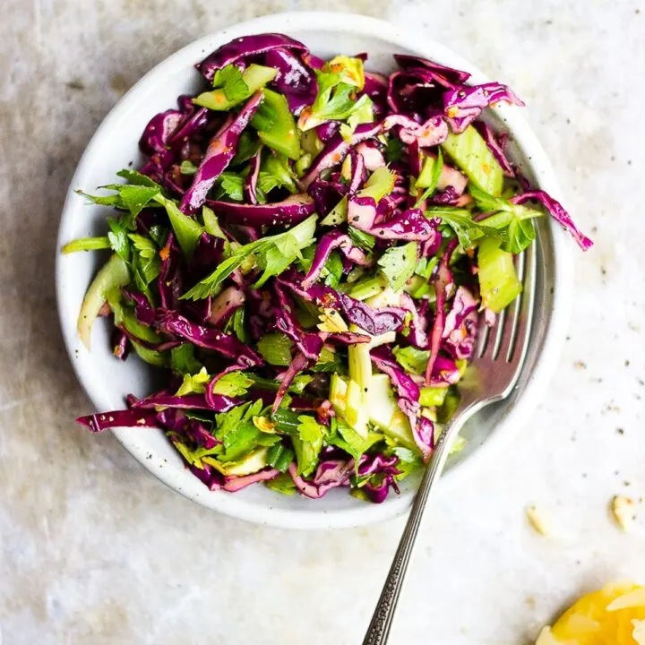 red cabbage celery salad in a bowl with lemon