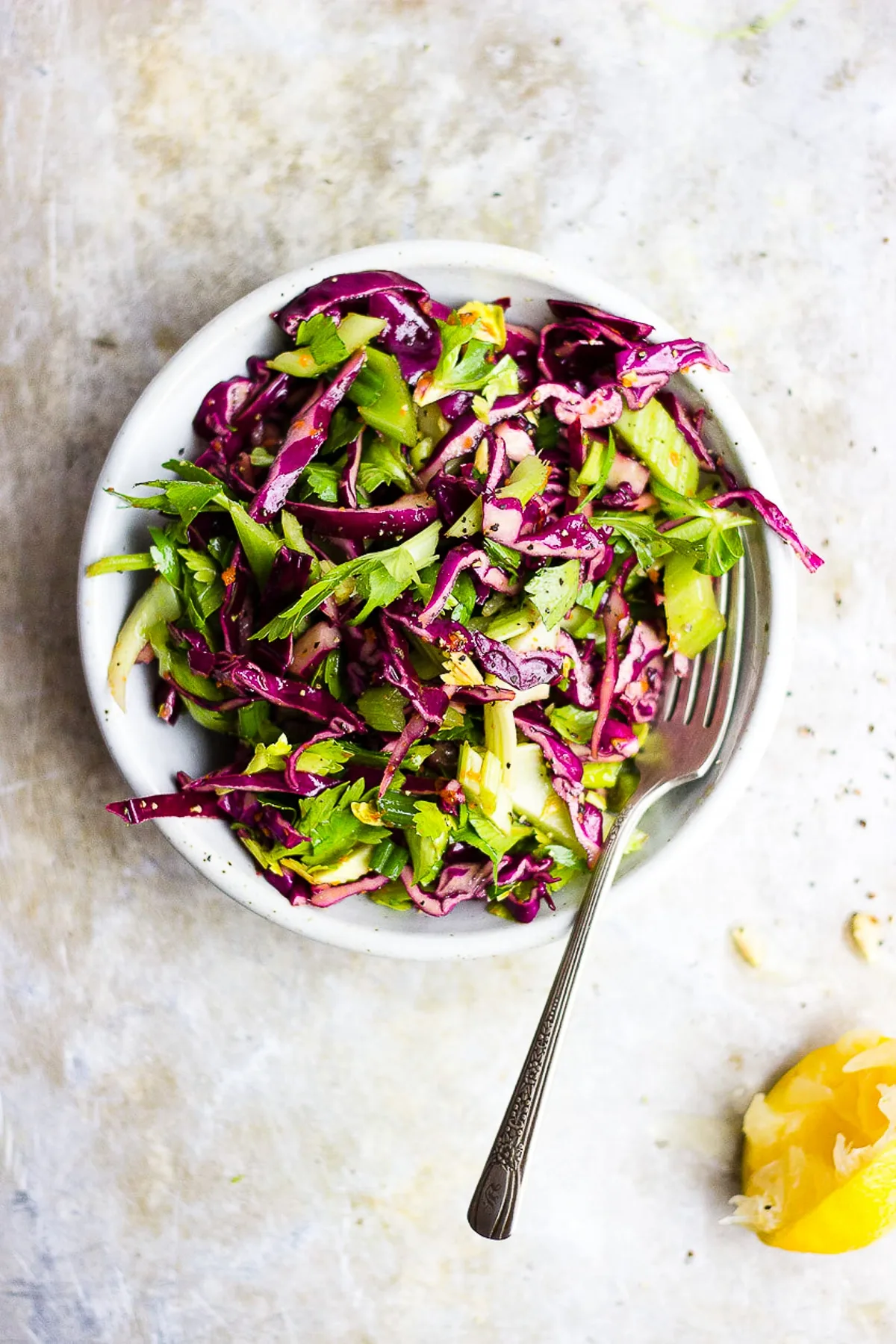 red cabbage celery salad in a bowl with lemon