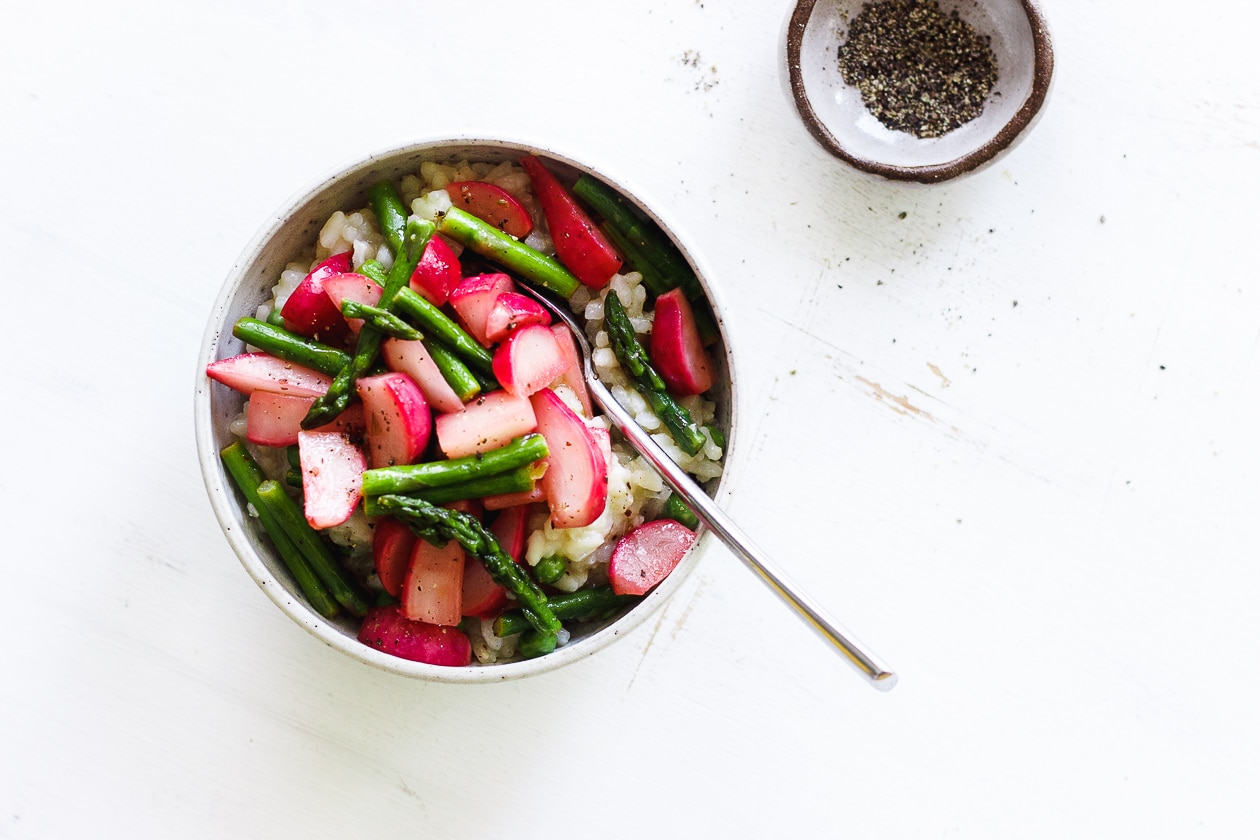 vegan risotto with radishes and asparagus in a bowl