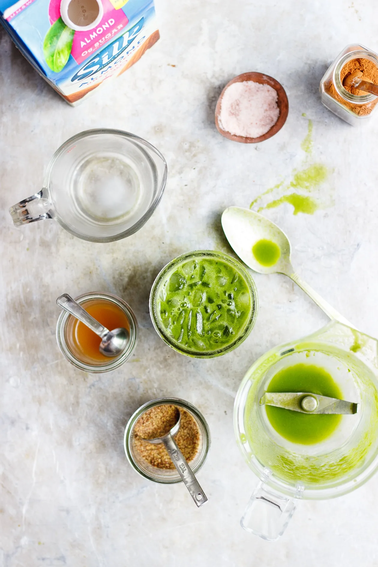 green smoothie with empty blender and spoon