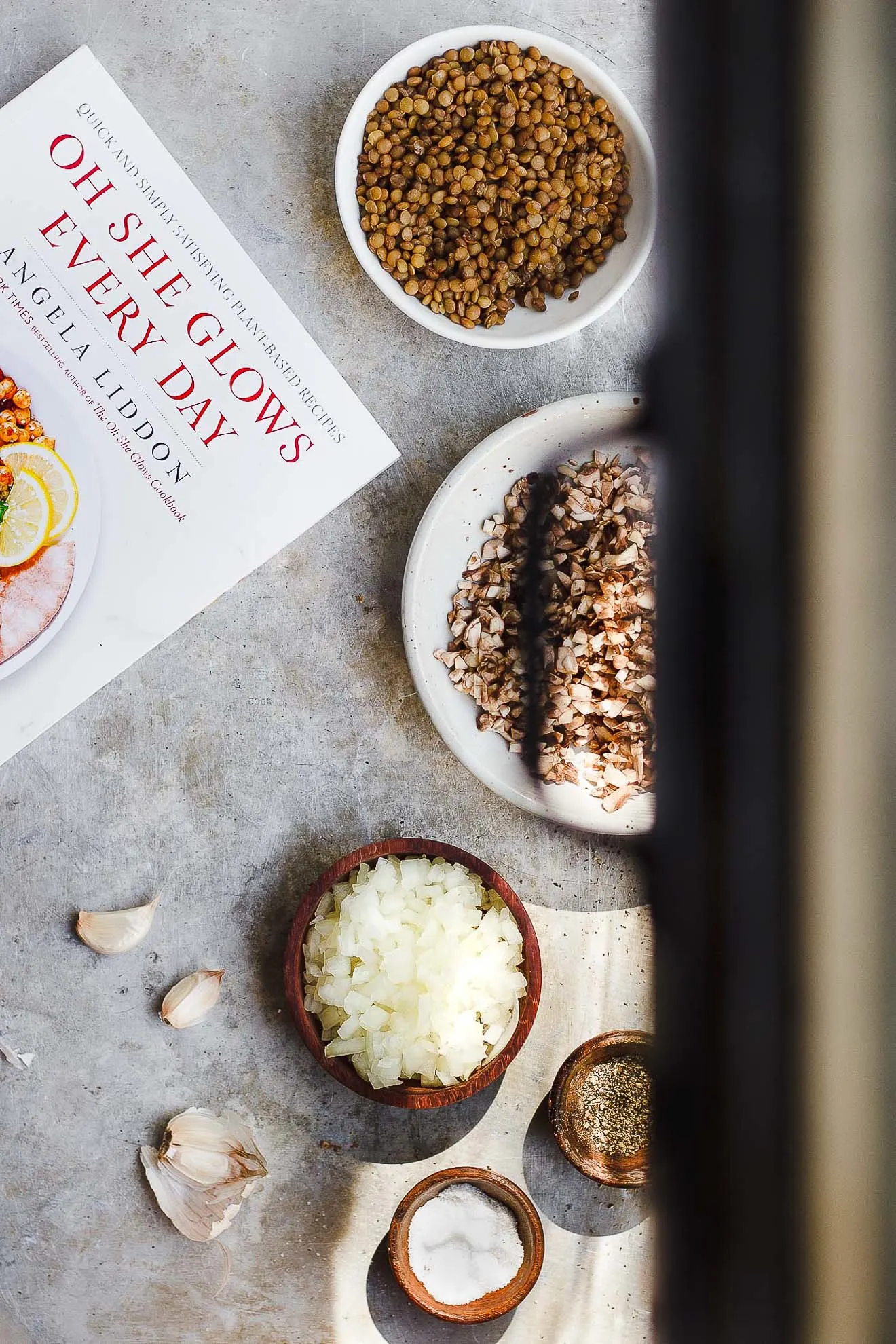 cookbook next to lentils, mushrooms, onions and garlic