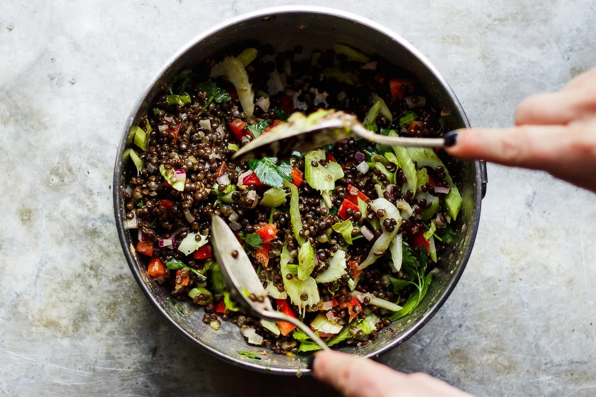 spoons mixing a lentil salad