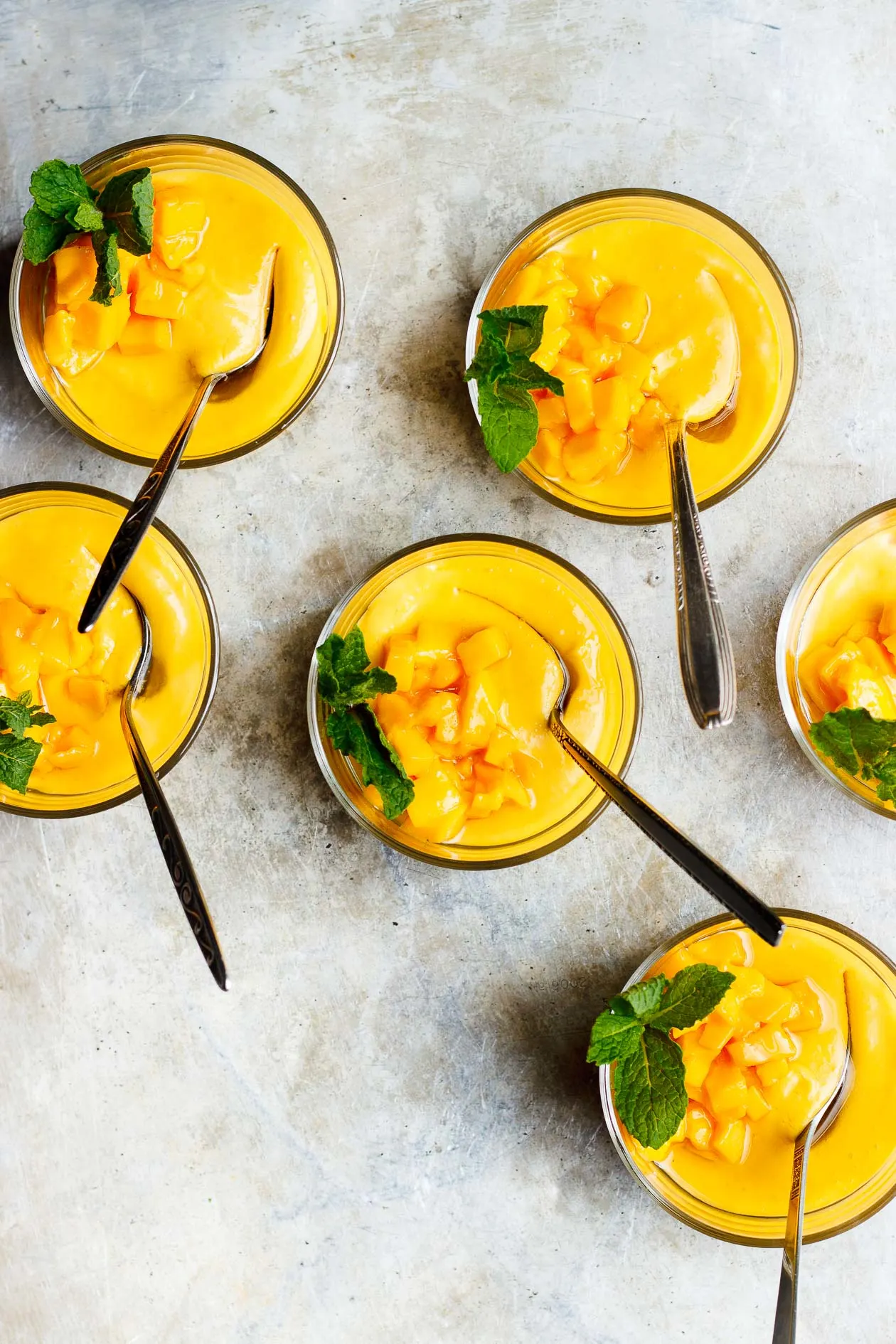 mango pudding in glass ramekins with mint sprig