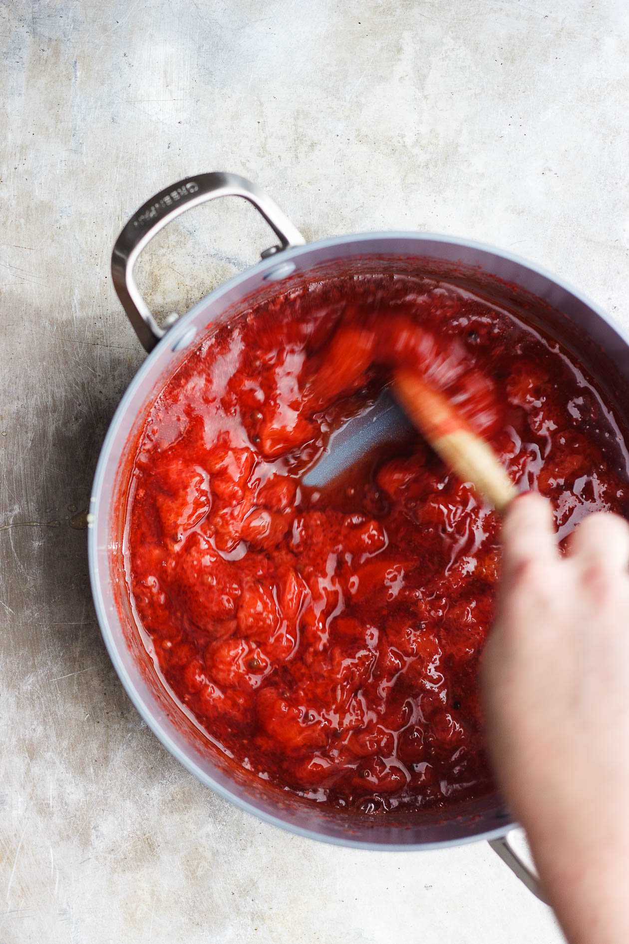 stirring berries sauce in a pot