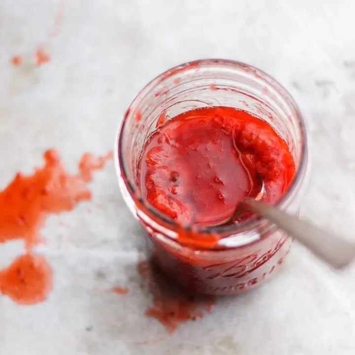strawberry sauce in a jar with spoon