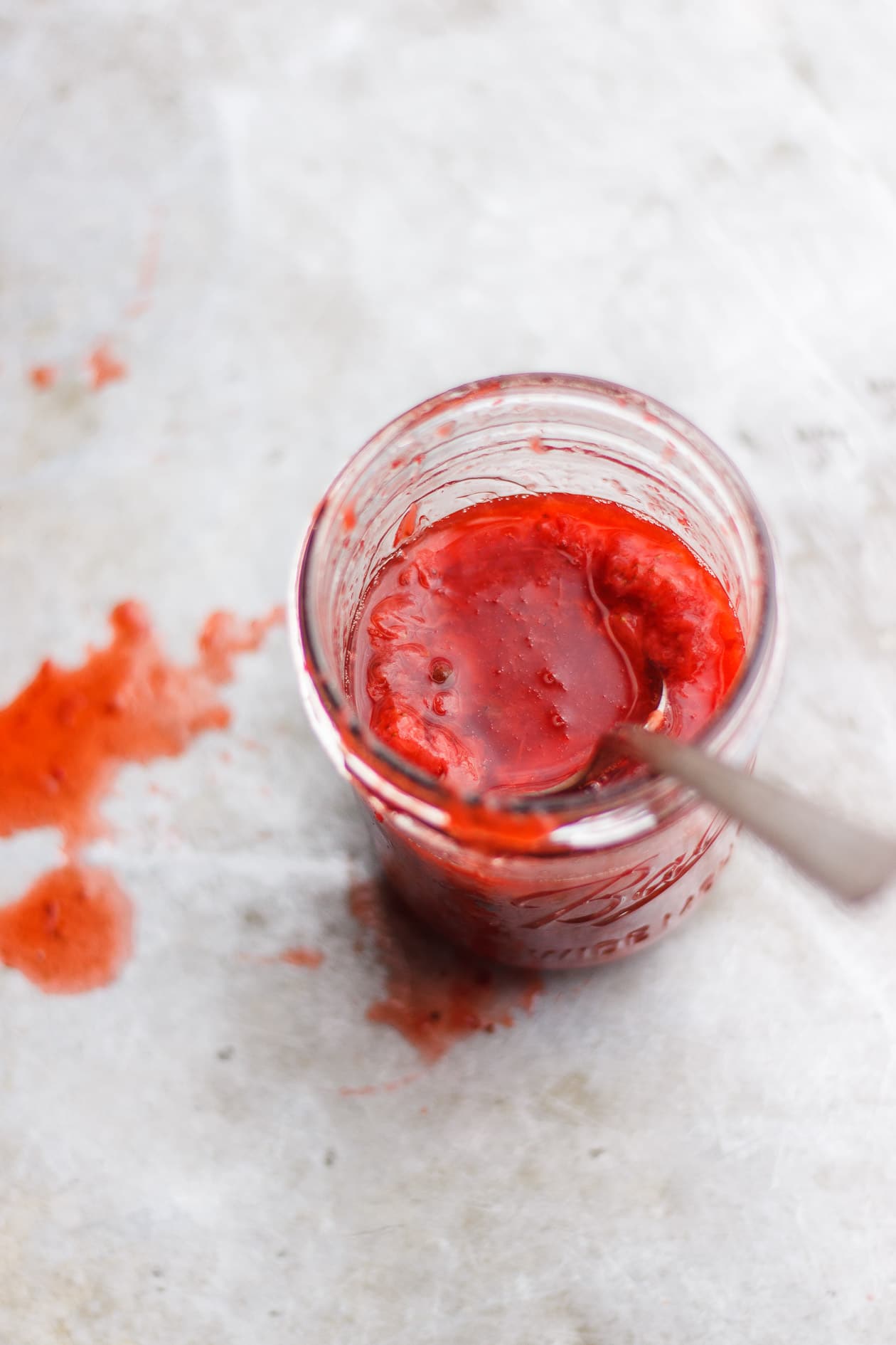strawberry sauce in a jar with spoon
