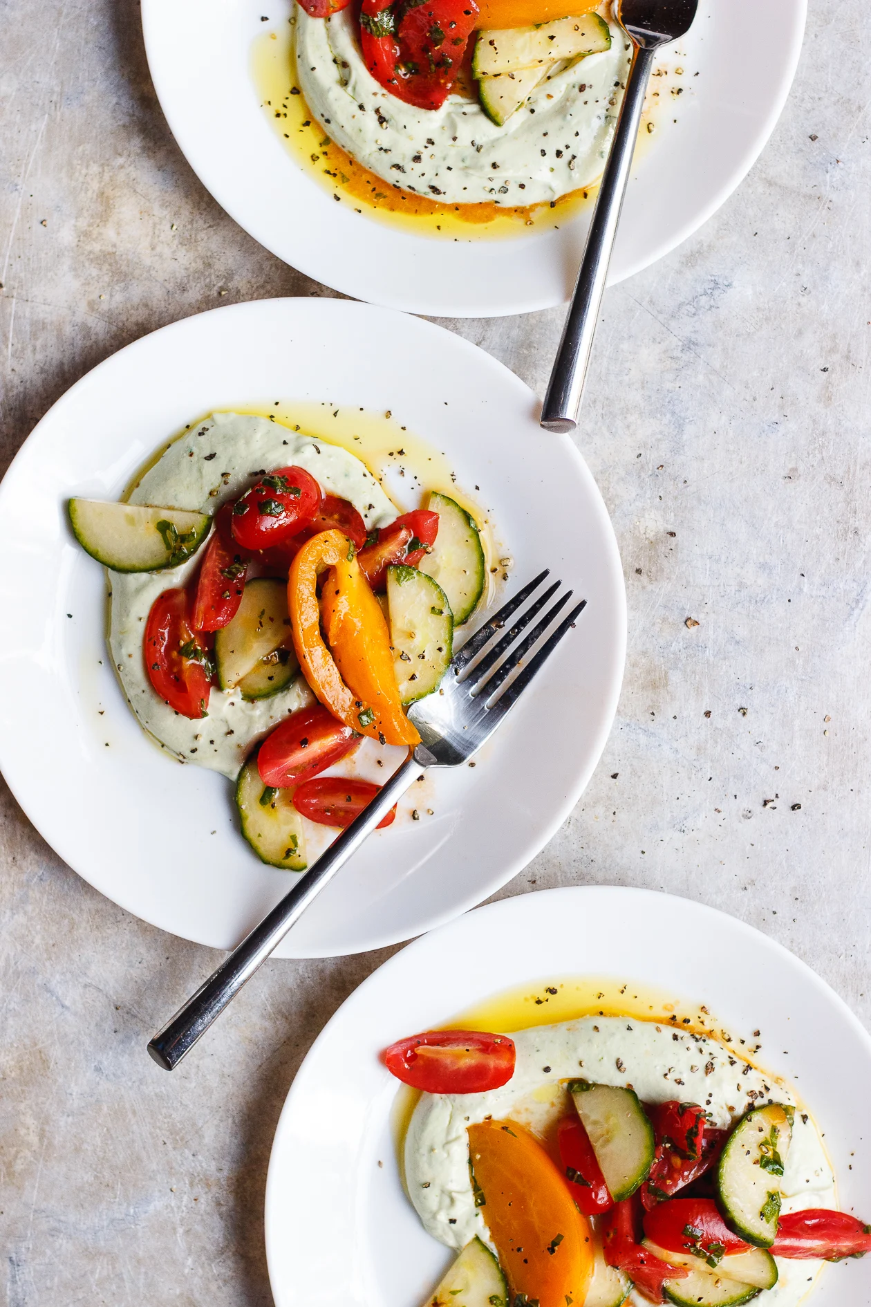 Basil Whipped Ricotta with Tomato Salad | A late summer tomato and cucumber salad on a bed of basil whipped ricotta. The best way to use up the bountiful end of summer produce.