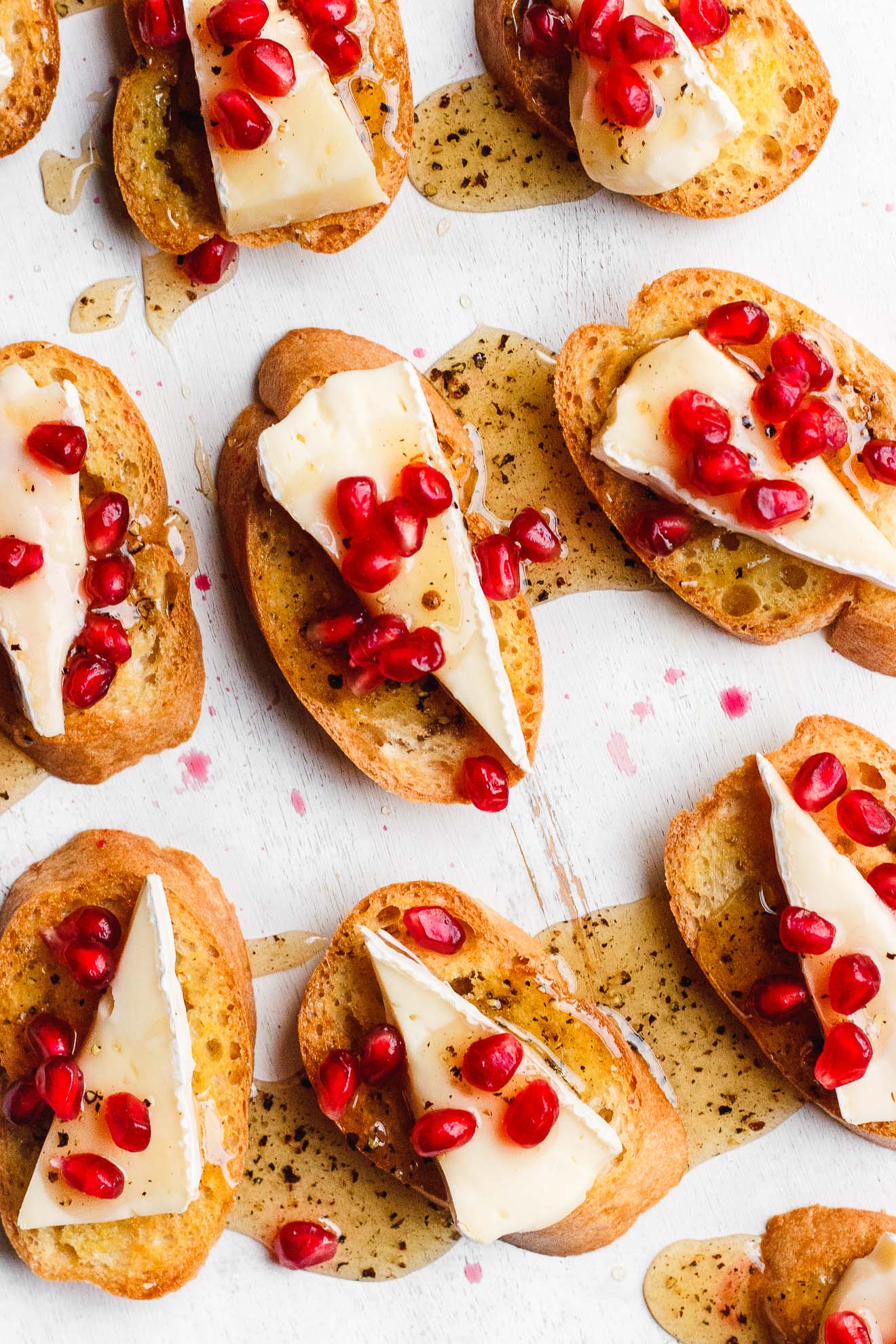 brie crostini topped with black pepper honey and pomegranate