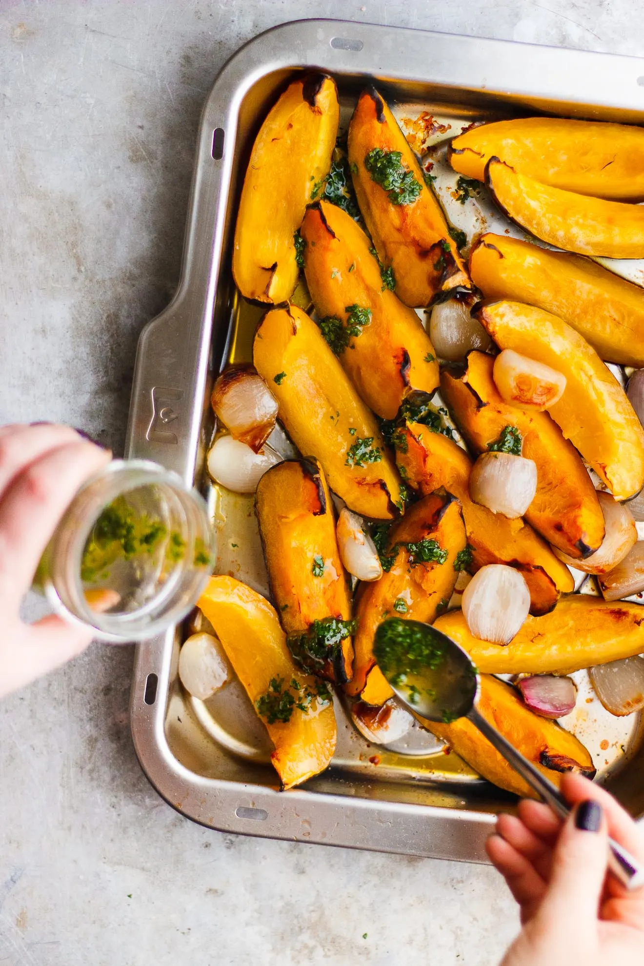 drizzling parsley oil onto roasted acorn squash 