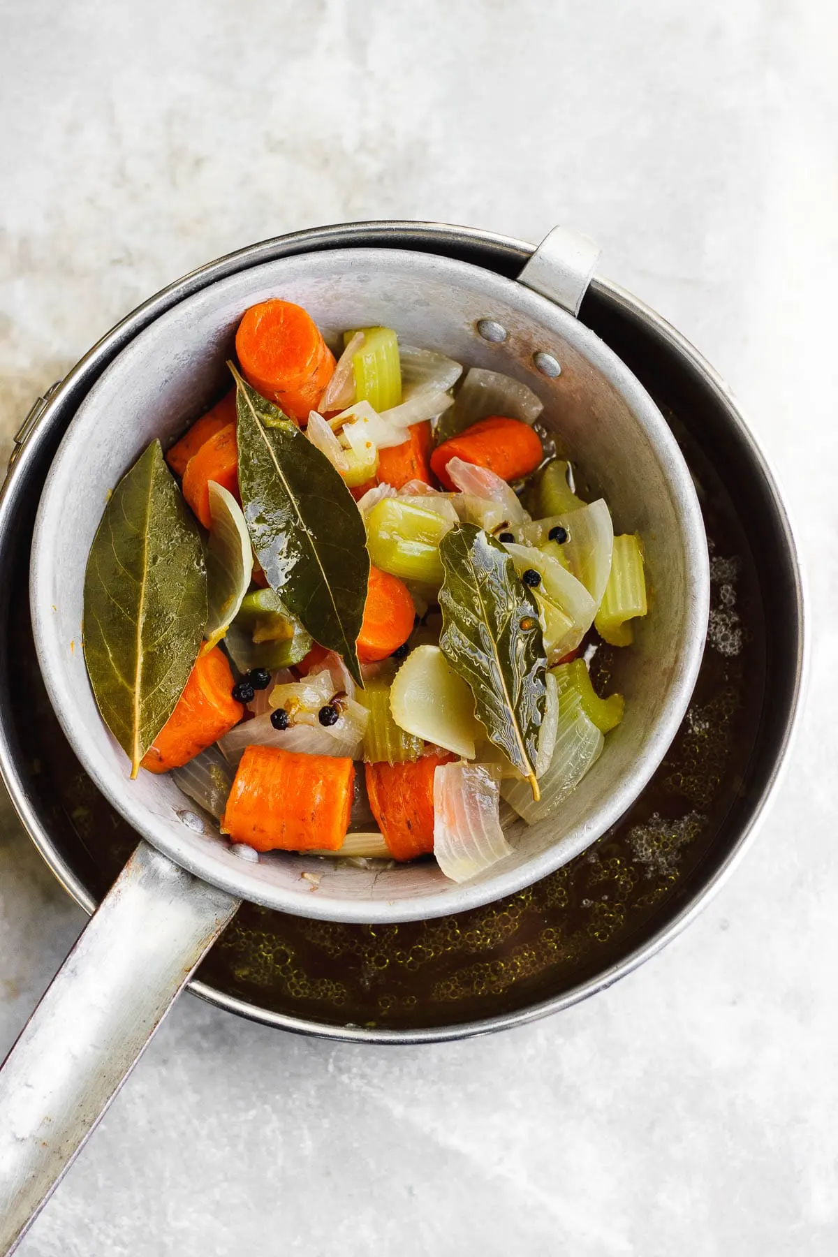 A healing, soothing, restorative vegetable broth flavored with bay leaf and peppercorn. A vegan, nutrient-dense sipping broth or for using in recipes. #veganbroth #vegetablebroth #bayleafrecipes #restorativebroth #sippingbroth