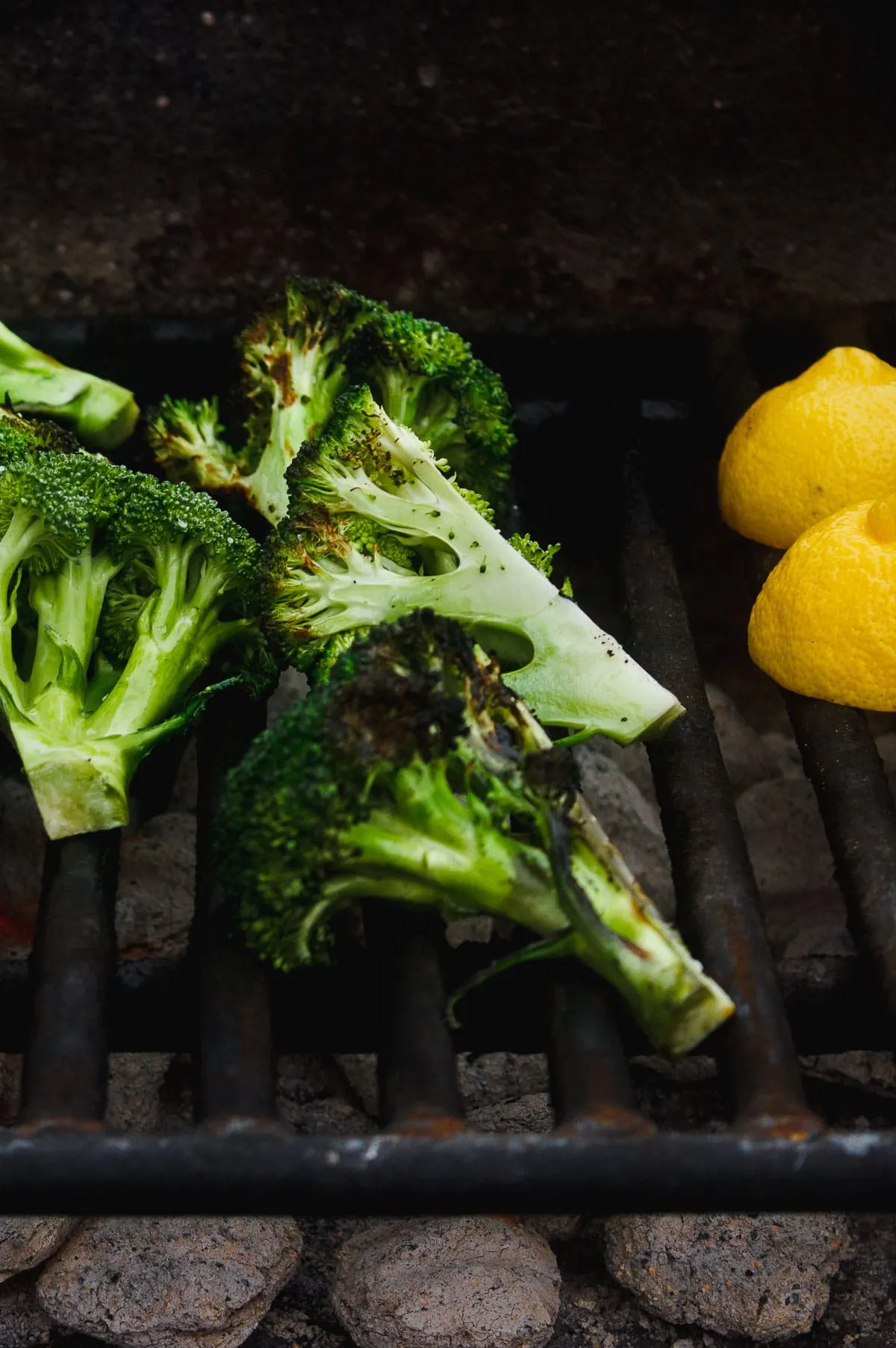 Grilled broccoli that is tossed in a zesty, charred lemon and parsley sauce. A vegan grilled side dish for anytime of year. #grilledbroccoli #grilledlemon #charredbroccoli