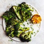 Grilled broccoli that is tossed in a zesty, charred lemon and parsley sauce. A naturally vegan and gluten-free side dish. #grilledbroccoli #grilledlemon #charredbroccoli