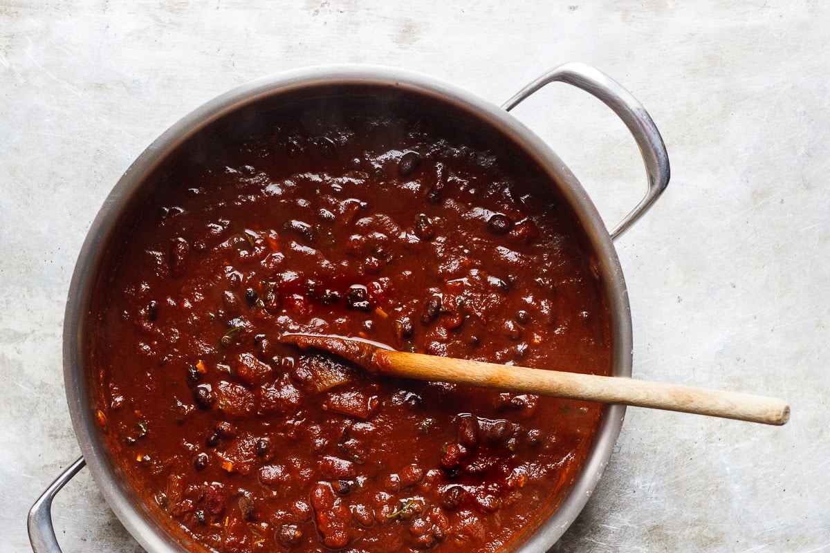 vegan chili in pot with wooden spoon