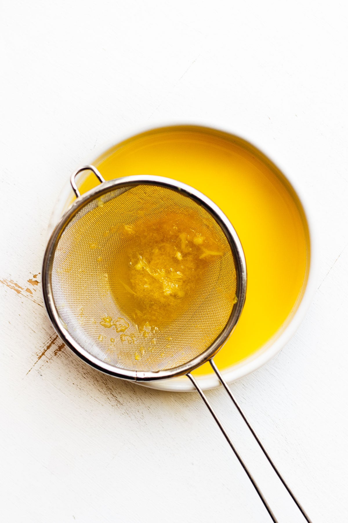 orange zest and pulp in a strainer