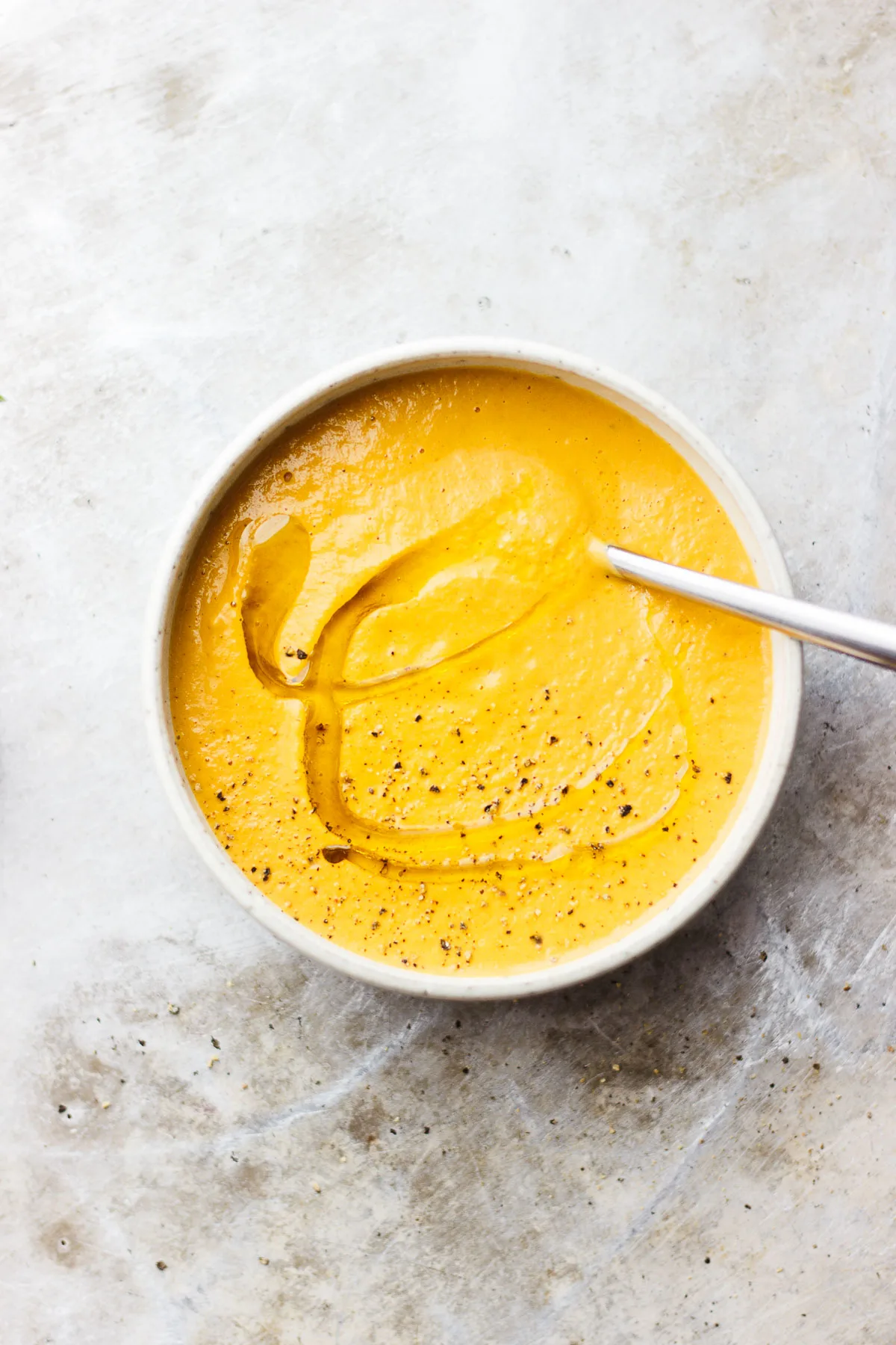 creamy carrot soup in bowl with spoon