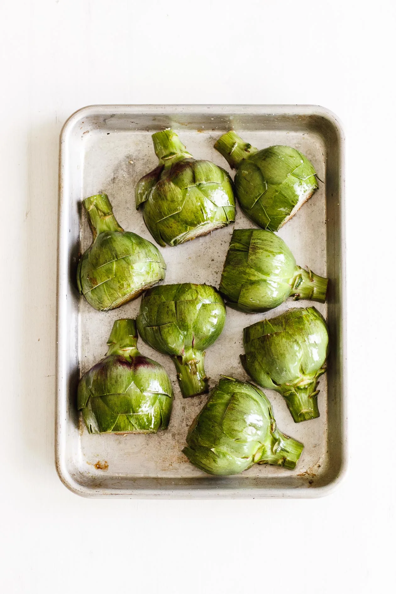 halved artichokes on a sheet pan