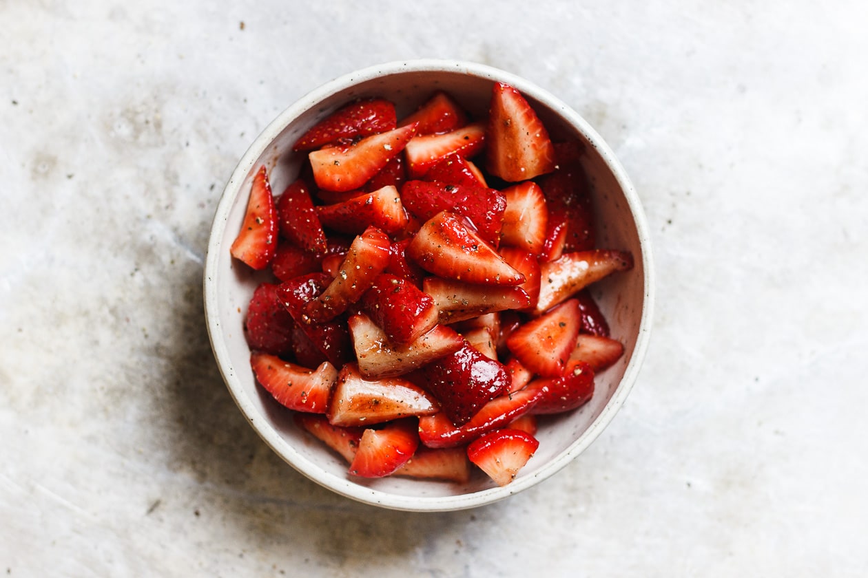 macerated strawberries in a bowl with balsamic and black pepper