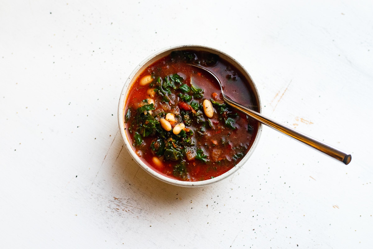 bowl of tomato kale soup with spoon