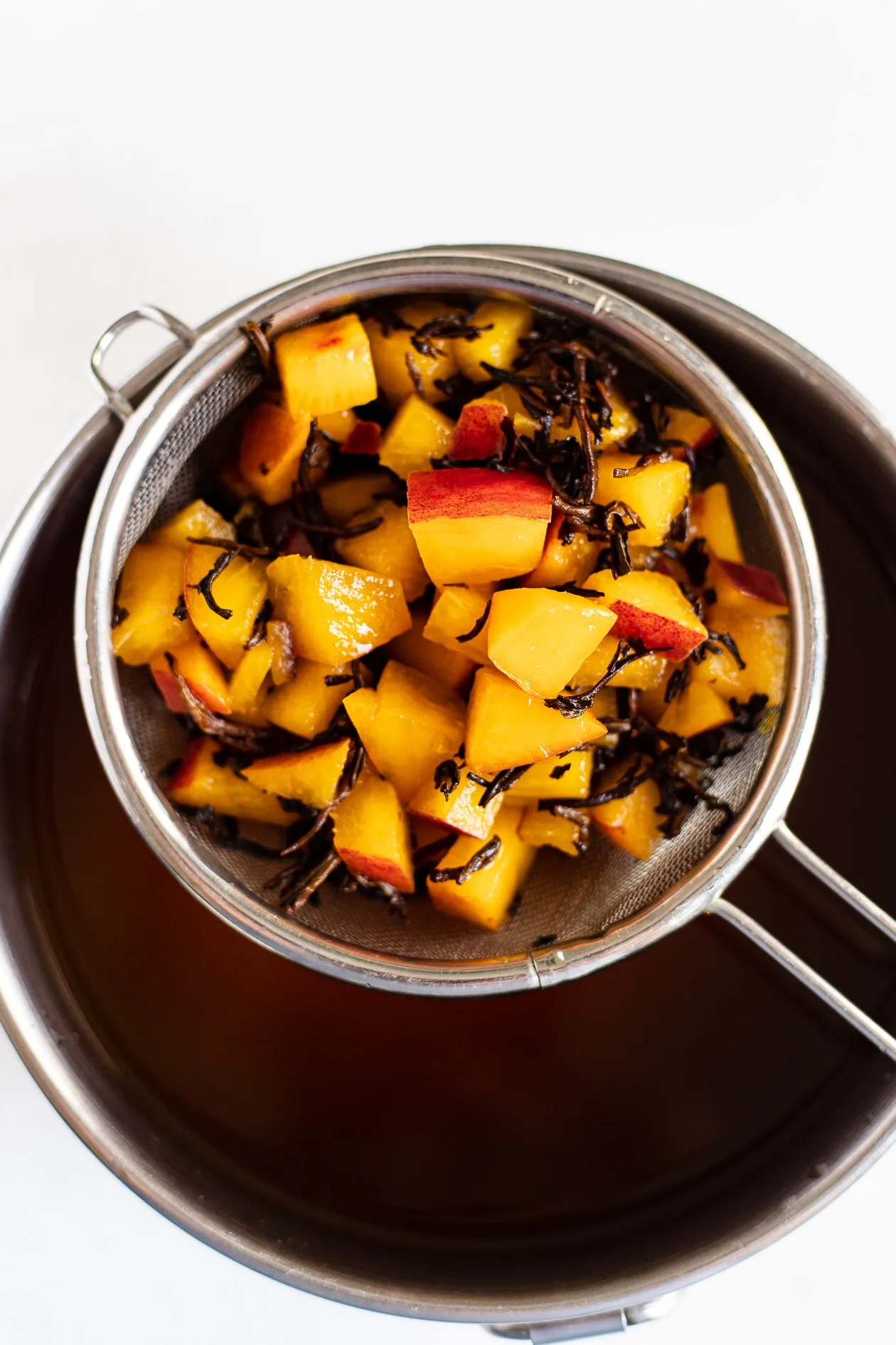 cold brew peach black tea in strainer